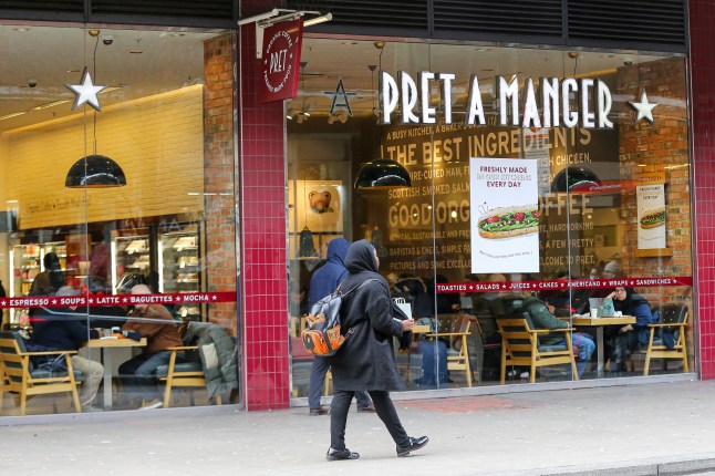 A woman walks past a branch of Pret A Manger in London