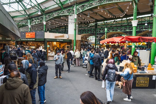 Bustling crowd inside Borough Market with shoppers exploring food stalls