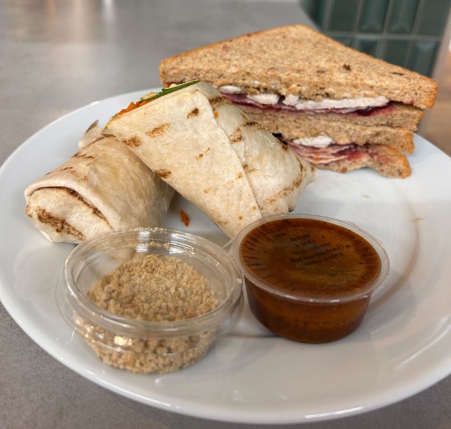 The The Turkey Feast Sandwich and Dippable Turkey & Gravy Double Dip Wrap on a plate with a pot of gravy