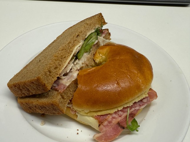 A closer look at the brie and bacon bagel and half the Turkey BLT on a plate