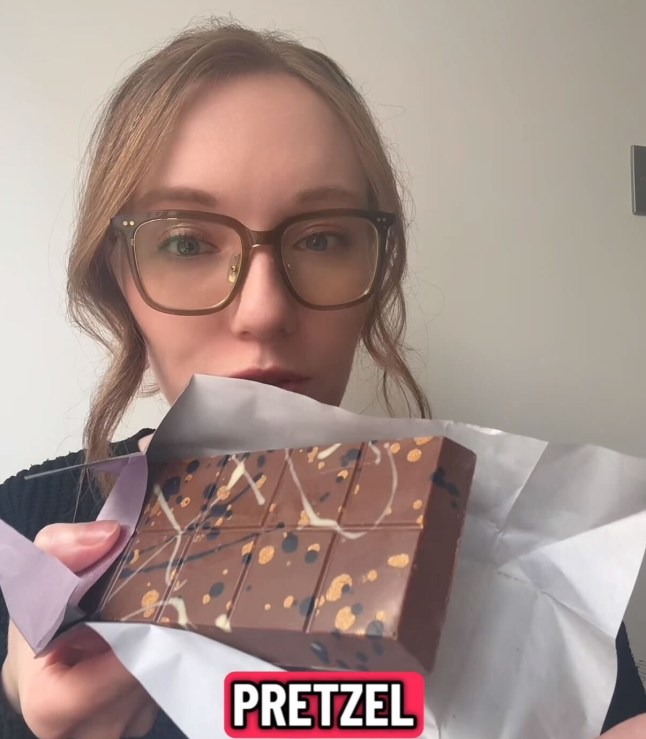 Courtney holding up the Milk Chocolate and Pretzel bar by Fix