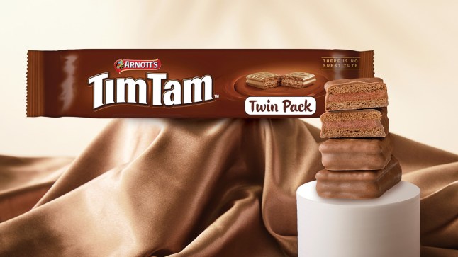 A twin pack of Tim Tam biscuits against a backdrop of chocolate.