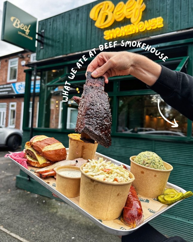 A hand holds up a plate of food at Beef Smokehouse in Manchester.